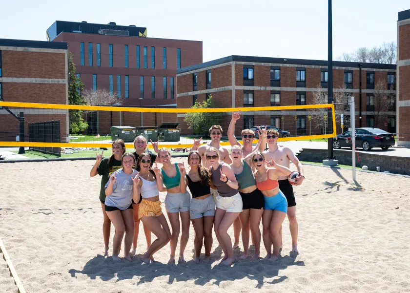 students posing after outdoor volleyball game