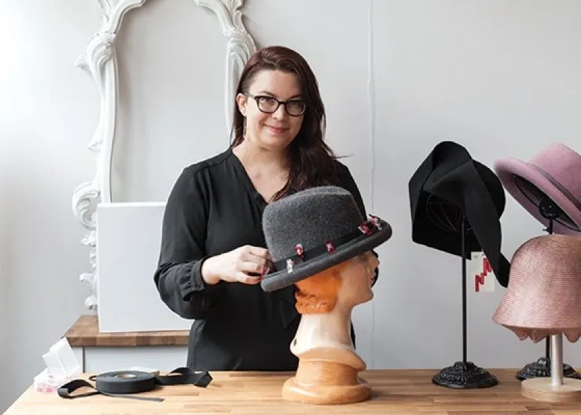 线上赌博app lecturer Anna Lee with her hat designs.