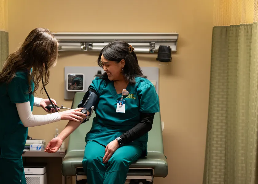 nursing students practicing with the blood pressure cuff