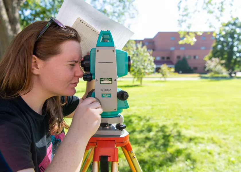 student uses a surveying tool