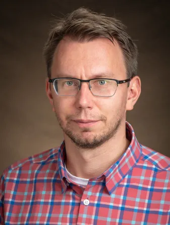 Alexey Leontyev smiling confidently at the camera