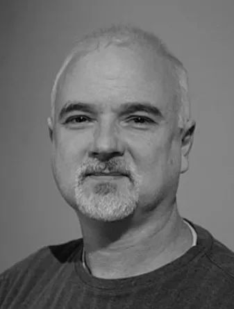 Wood smiling confidently at camera