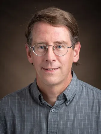 Alan Denton smiling confidently at camera.