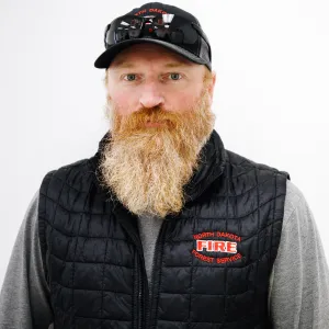 Photo of a man with a long red beard and sunglasses on top of his head with a baseball cap
