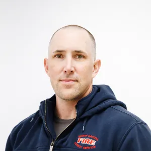 A man in a hoodie grinning