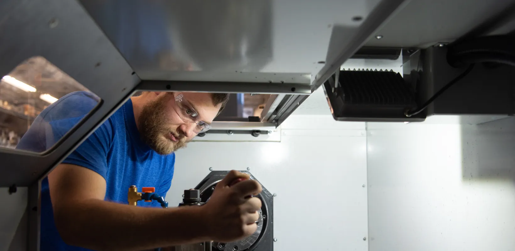 student calibrating a piece of machinery in a lab