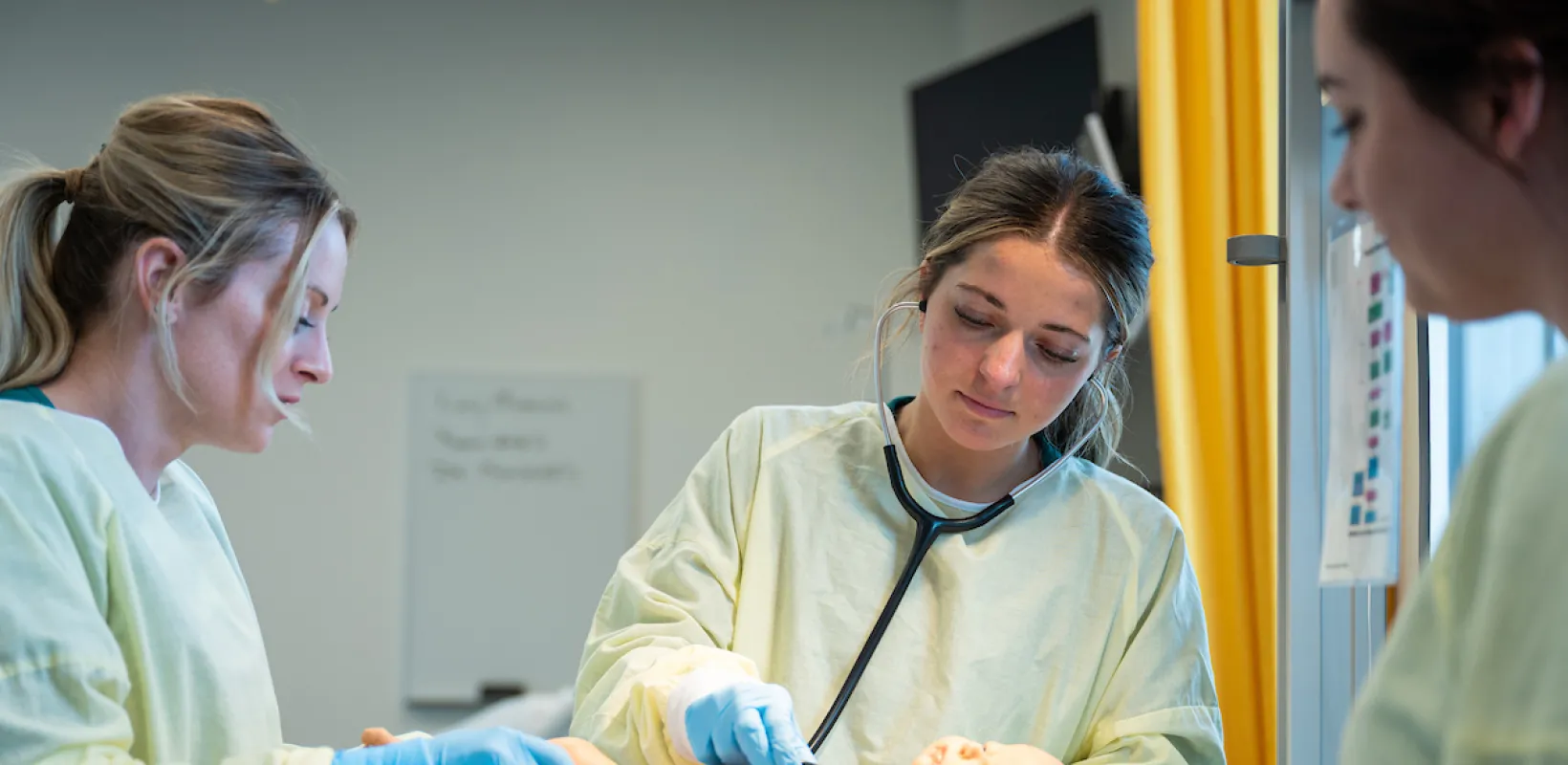 nursing students practicing on a baby manikin
