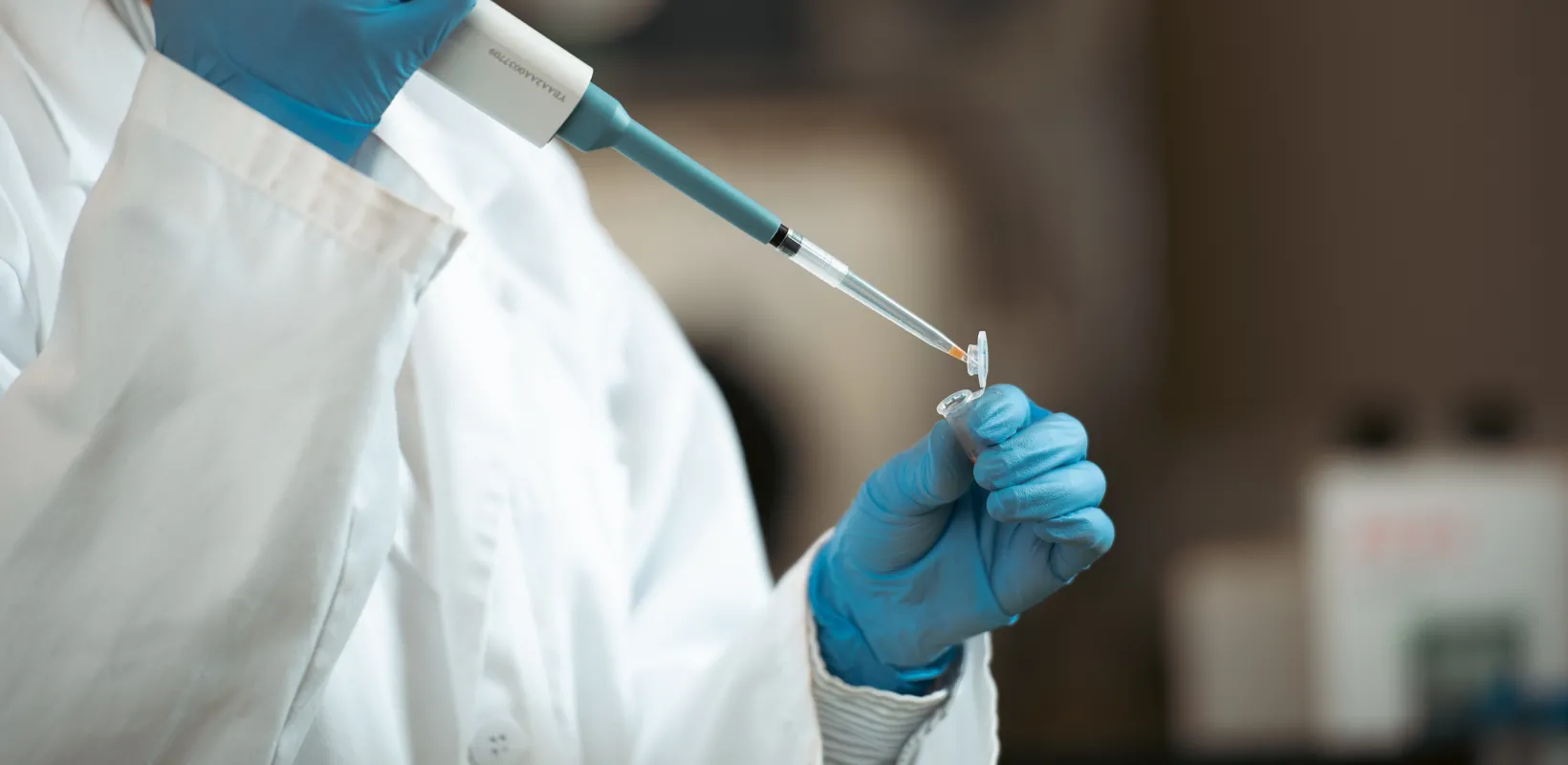 student filling a testing container in a lab