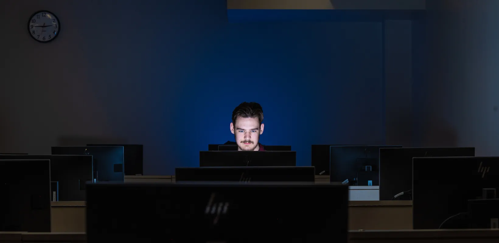 student working in a dark computer lab