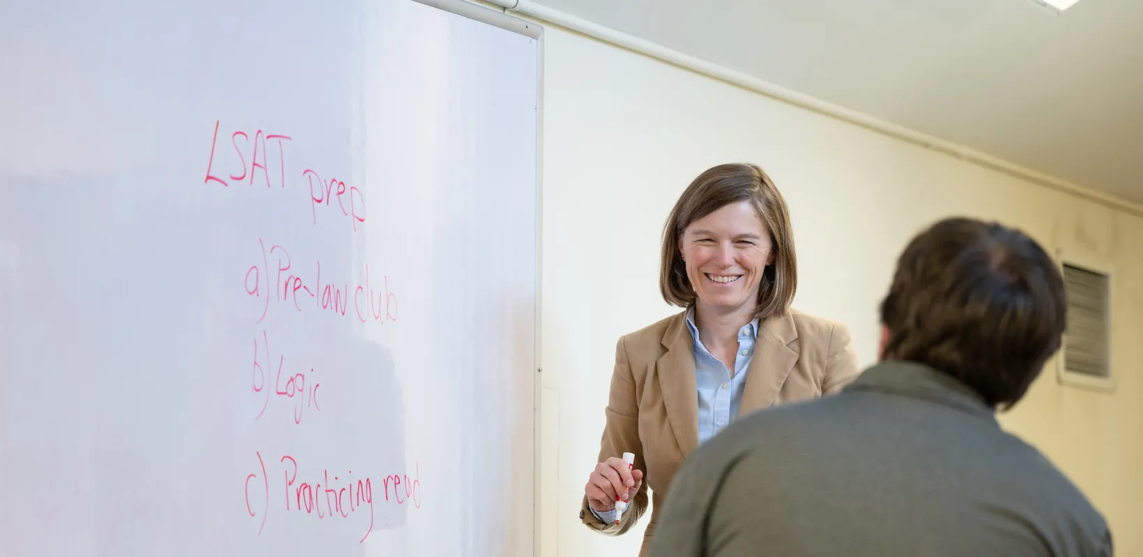 professor working with a student in front of a whiteboard