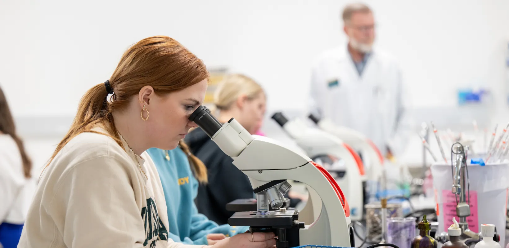 student looking at samples under a microscope