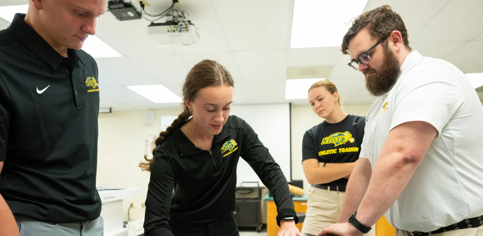 students practicing sports medicine on a mannequin 