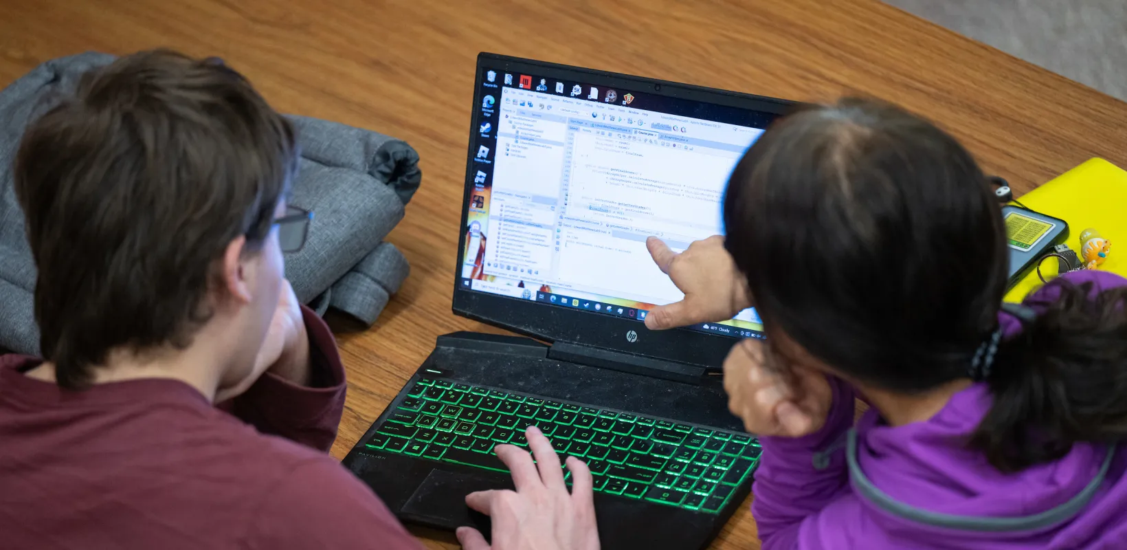 students reviewing code on a laptop screen
