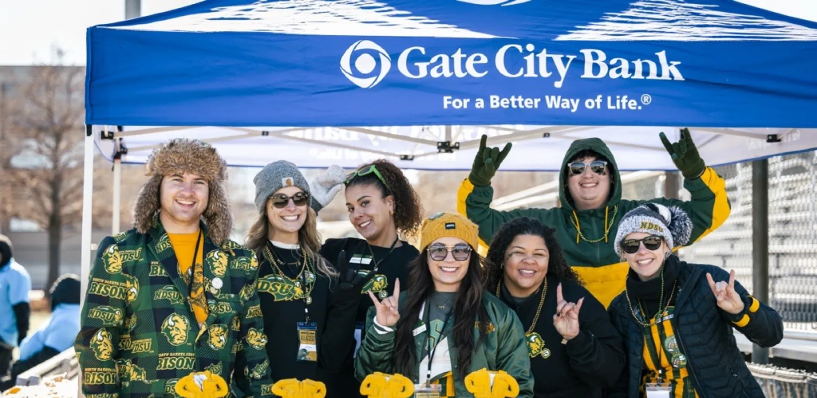 Gate City Bank tent outside with people dressed in 线上赌博app gear posing for a photo with swag items