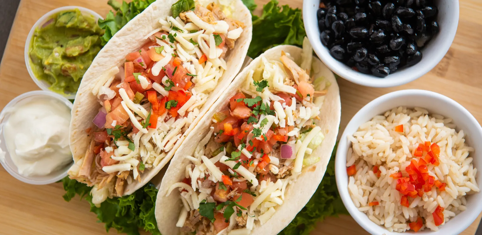 Two located chicken fajita tacos featured with black beans and rice