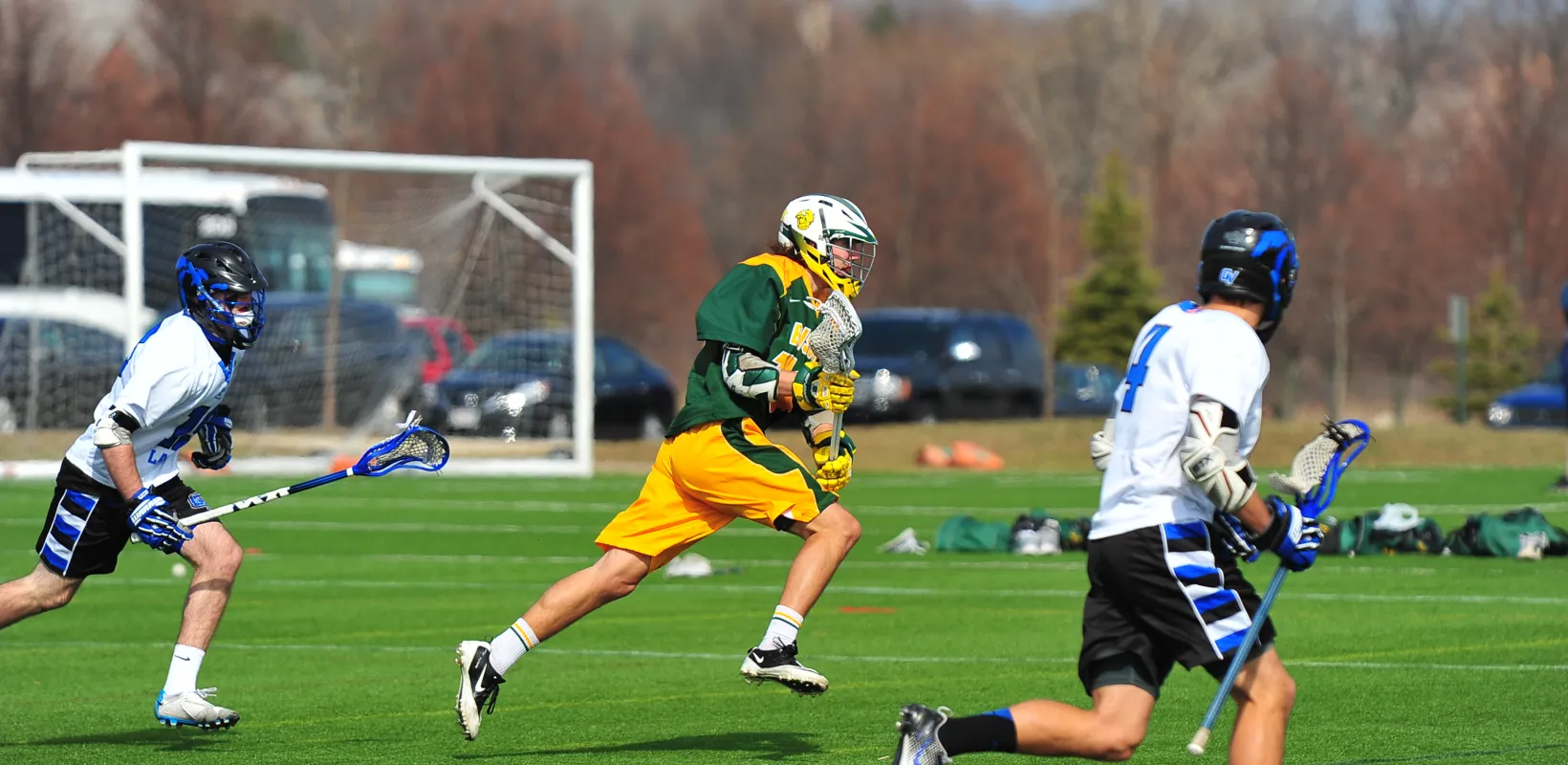 线上赌博app Lacrosse team playing on green field