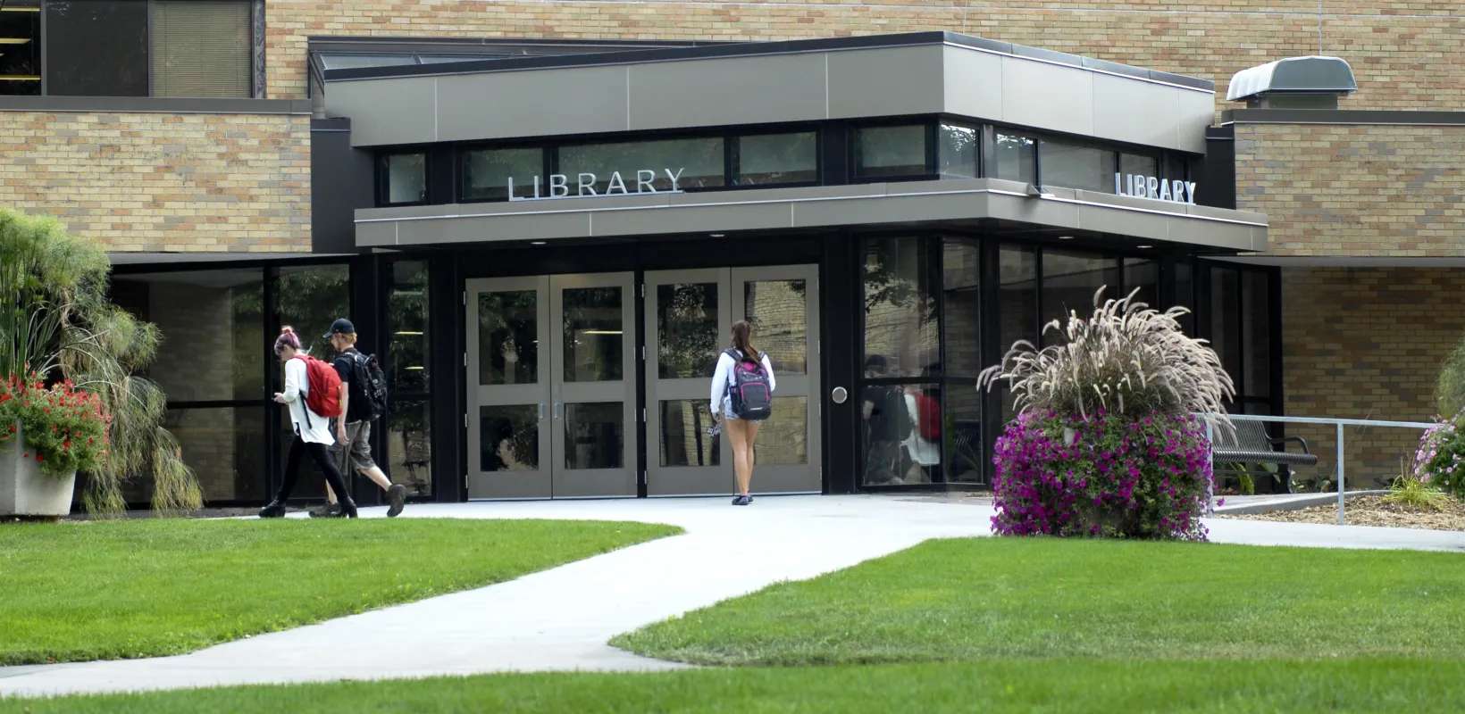 A student walking toward the entrance to the Main Library.