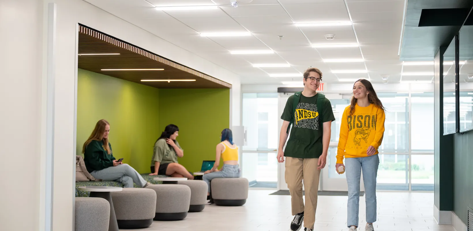two students walking through Pavek Hall entry way