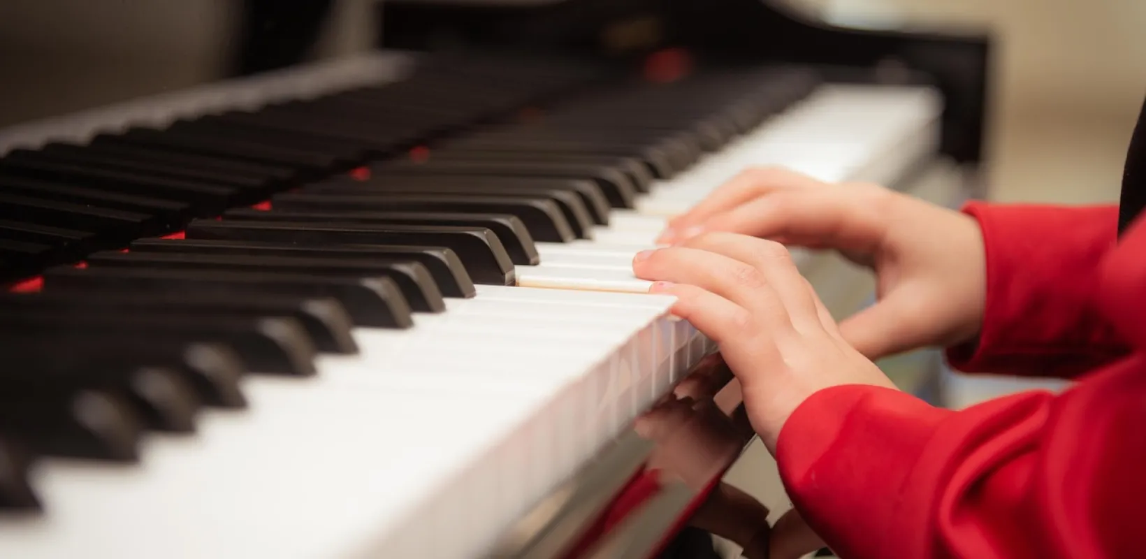 A closeup of a child's hands playing piano.