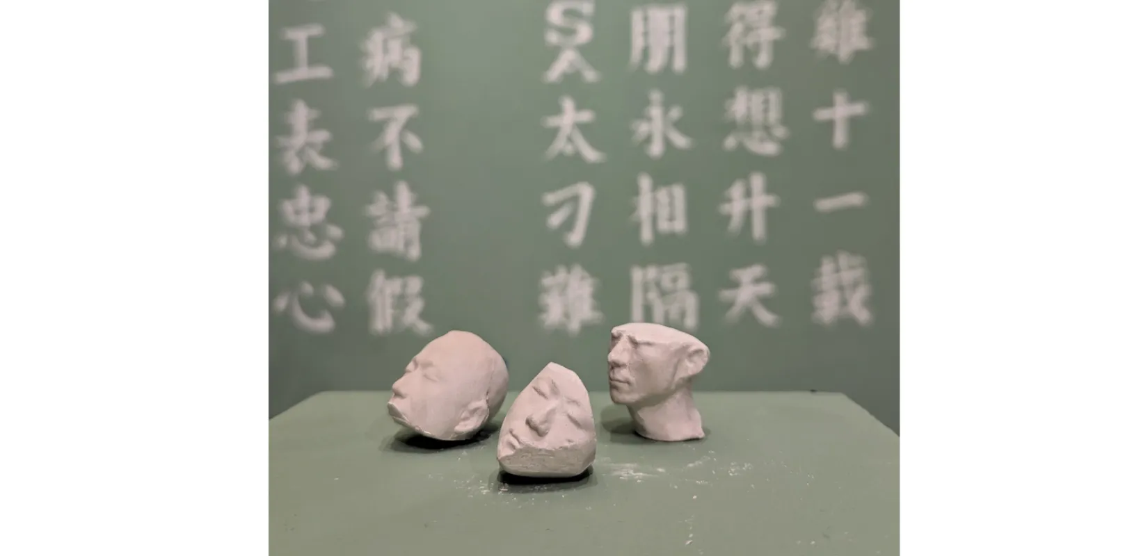 3 Chalk heads with chinese characters behind them