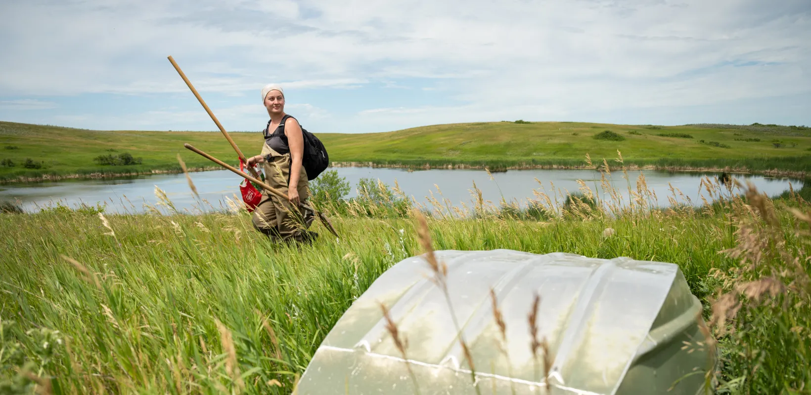 A graduate student completes field research in a wetland.