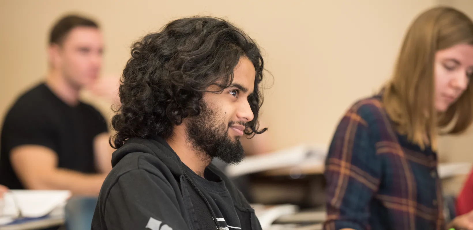 Student sitting in classroom setting looking at the front of the room.