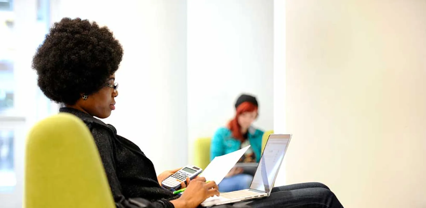 Student studying using laptop and calculator