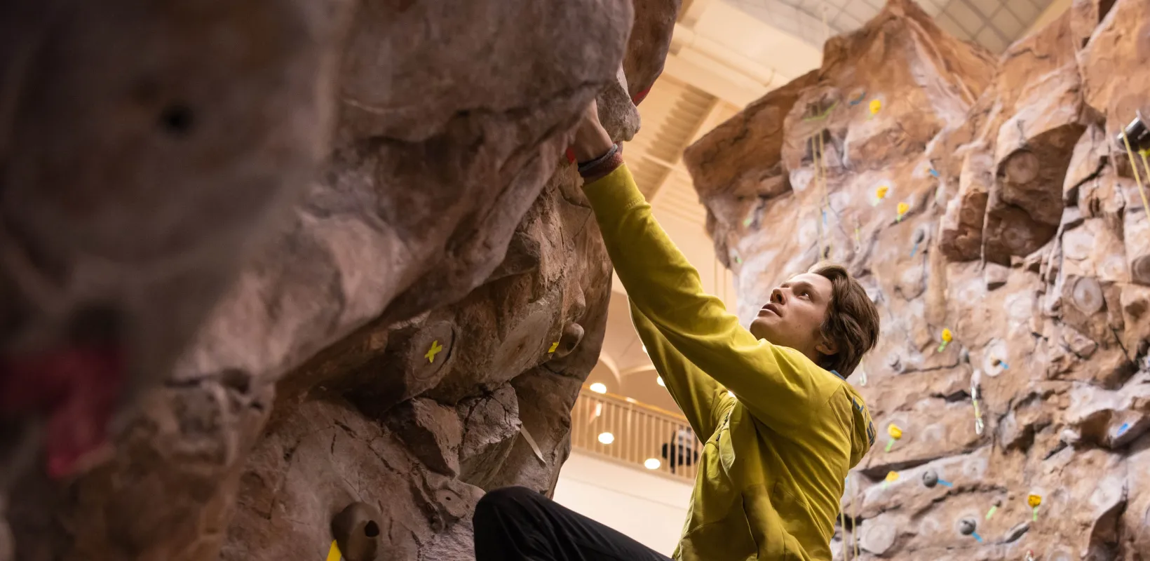Male student climbing on indoor rock wall