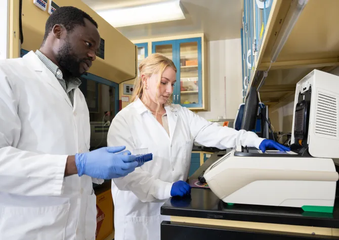 biology students placing samples in a testing machine