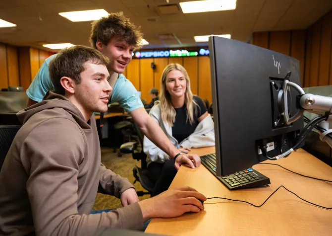students gathered around computer in a business class