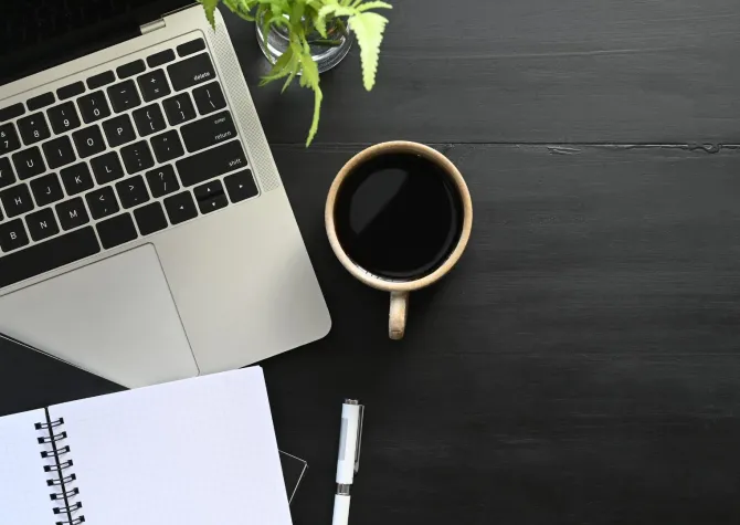 Laptop by cup of coffee