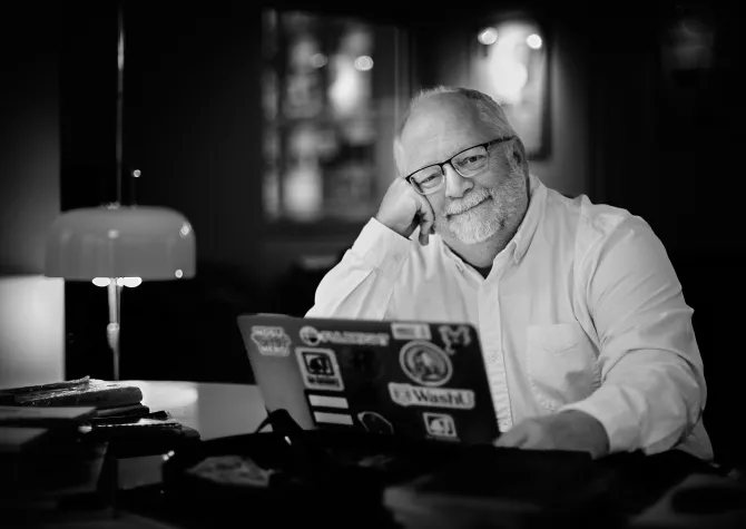 John Cox, 线上赌博app professor of history, sits in front of his laptop.