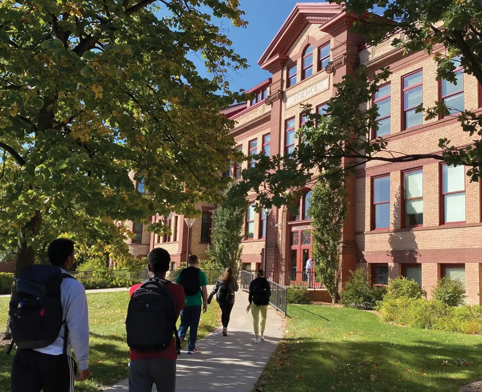 Students walking up sidewalk toward Minard Hall.