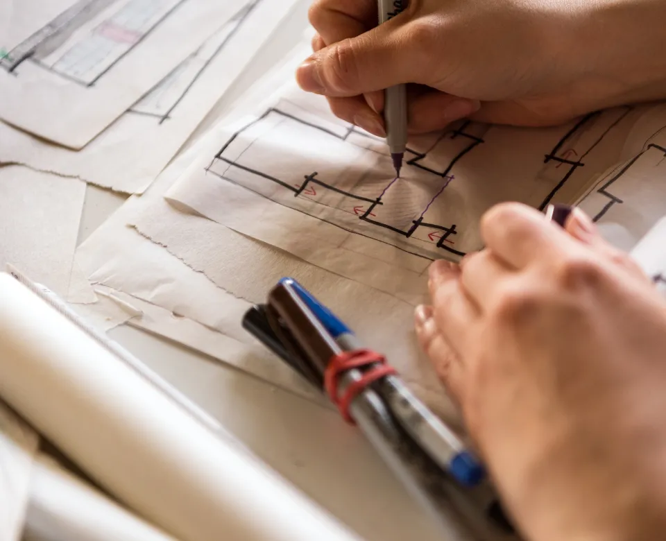 Hands working on design layout.