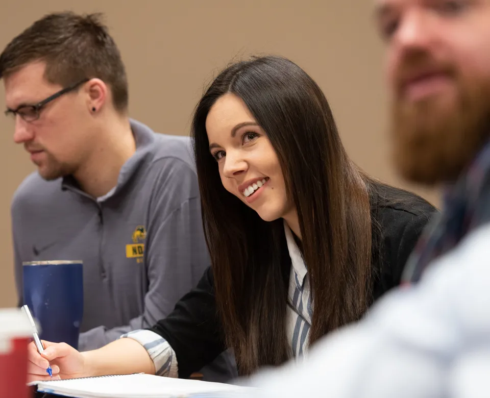 Student smiling and looking at front of classroom.