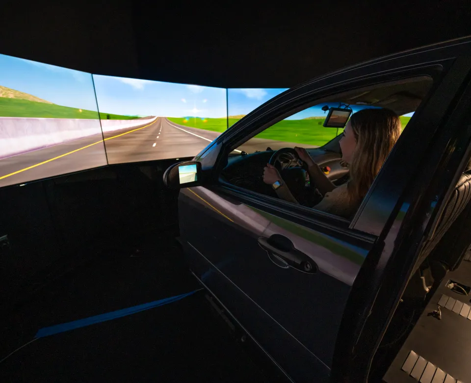 Student sitting in the driver seat of the driving simulator.