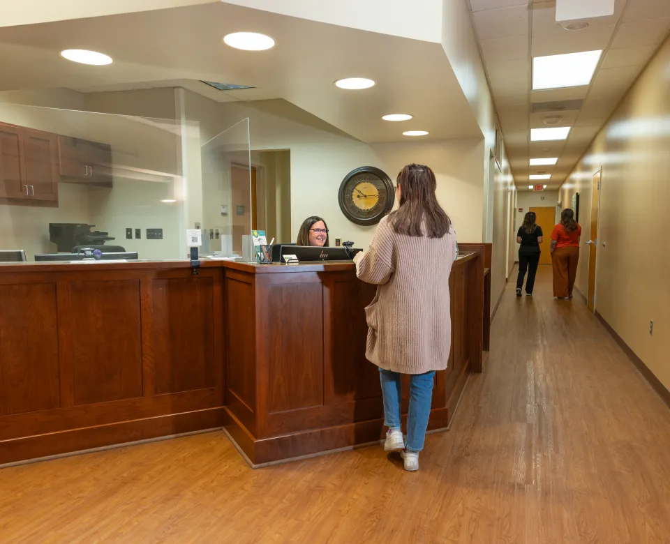 Student speaking with front desk staff at Student Health Service
