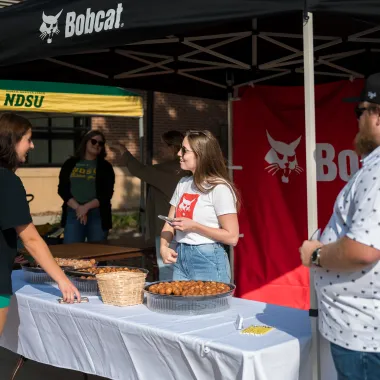 student approaching employer booth on campus
