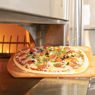 pizza going into the oven