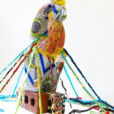 A fabric sculpture sits atop a brick