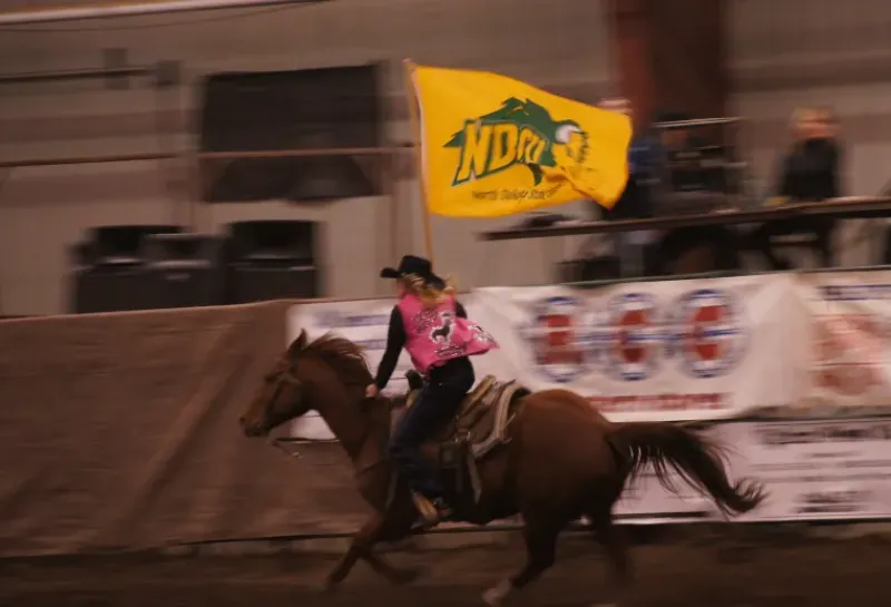 Girl riding horse at rodeo