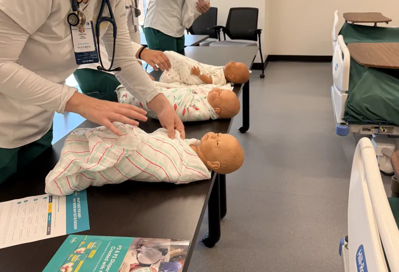 Nursing students swaddling sim babies