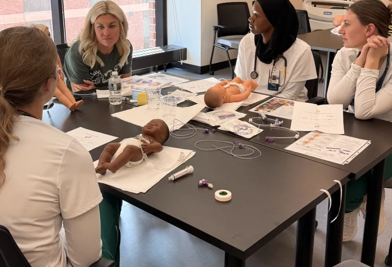 Nursing students discussing at tables