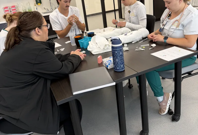 Nursing students completing activities at tables