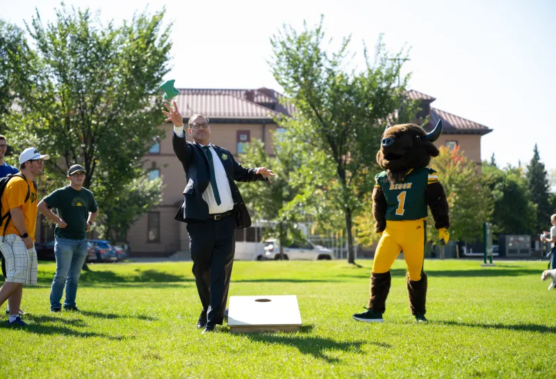 President Cook playing cornhole against Thundar as part of Homecoming 2025 week 