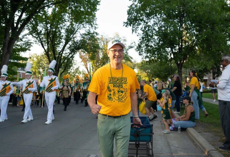 President Cook handing out candy to young Bison fans during the Homecoming 2025 parade