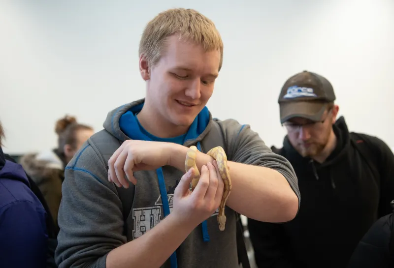Students holding a snake at the 线上赌博app 达尔文的日子 Evolution Pop-Up Museum