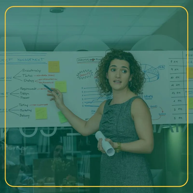 Woman business coaching pointing to a white board