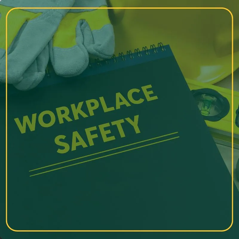 Workplace Safety notebook with safety gloves and a hardhat sitting on a table