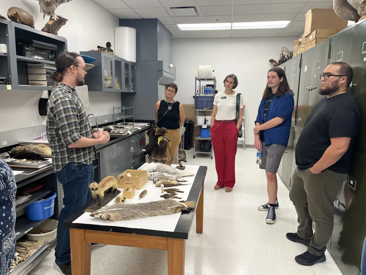 People stand in a half cirlce talking in a lab